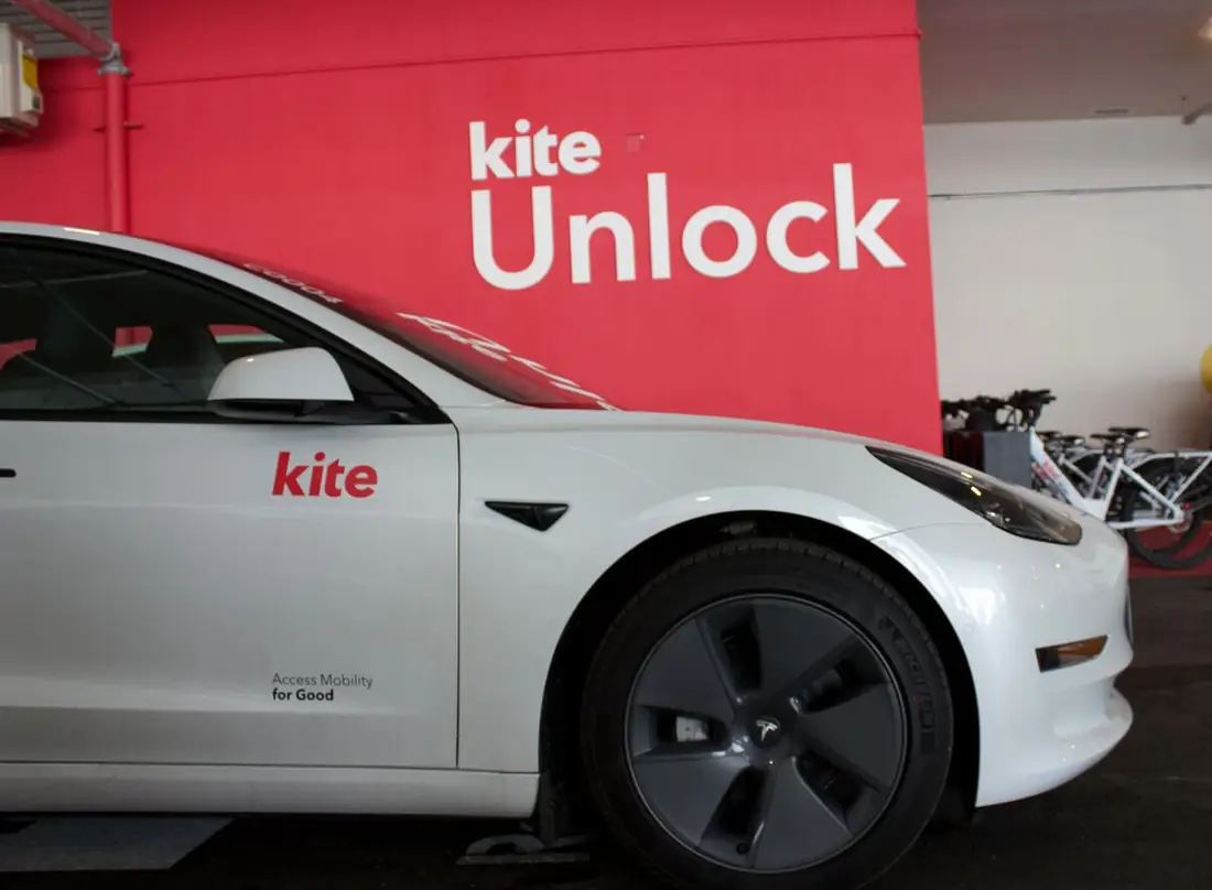A Kite car parked at The Spoke hub by the Kite Unlock wall